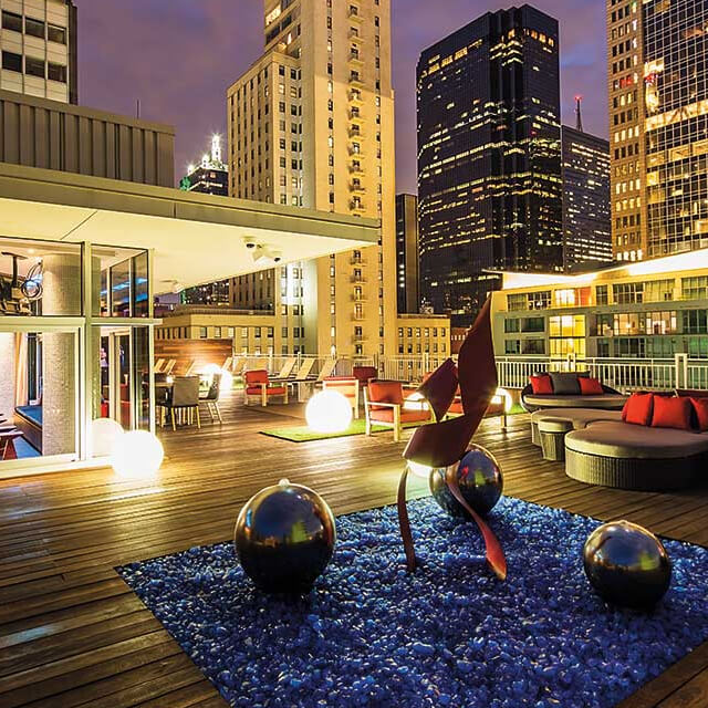 Outdoor terrace in a downtown location with artistic sculptures, lounge seating and lighting features
